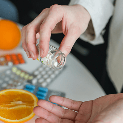 a woman puts supplements into her hand