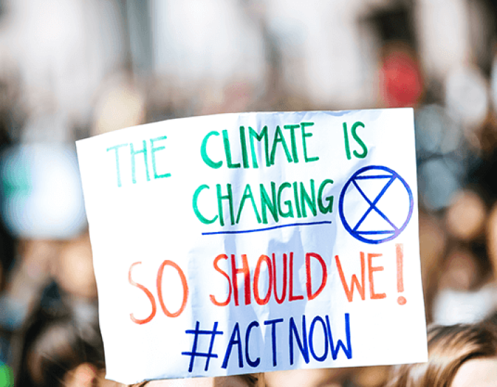 a climate change activism sign is held up