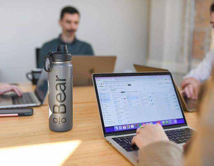 A close up of a laptop and waterbottle with Bear logo