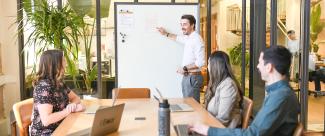 A development team in a conference room working off of a whiteboard